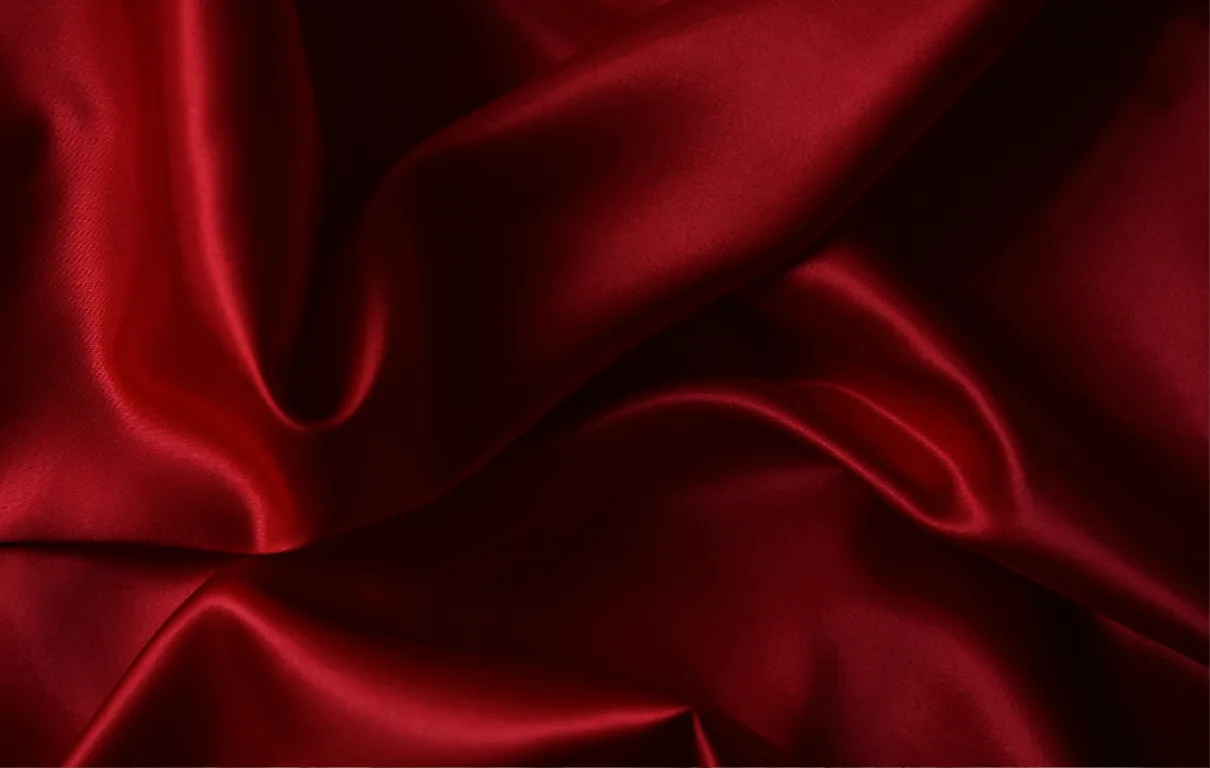 Deep red hemp-silk fabric draped in soft folds with a luminous sheen.